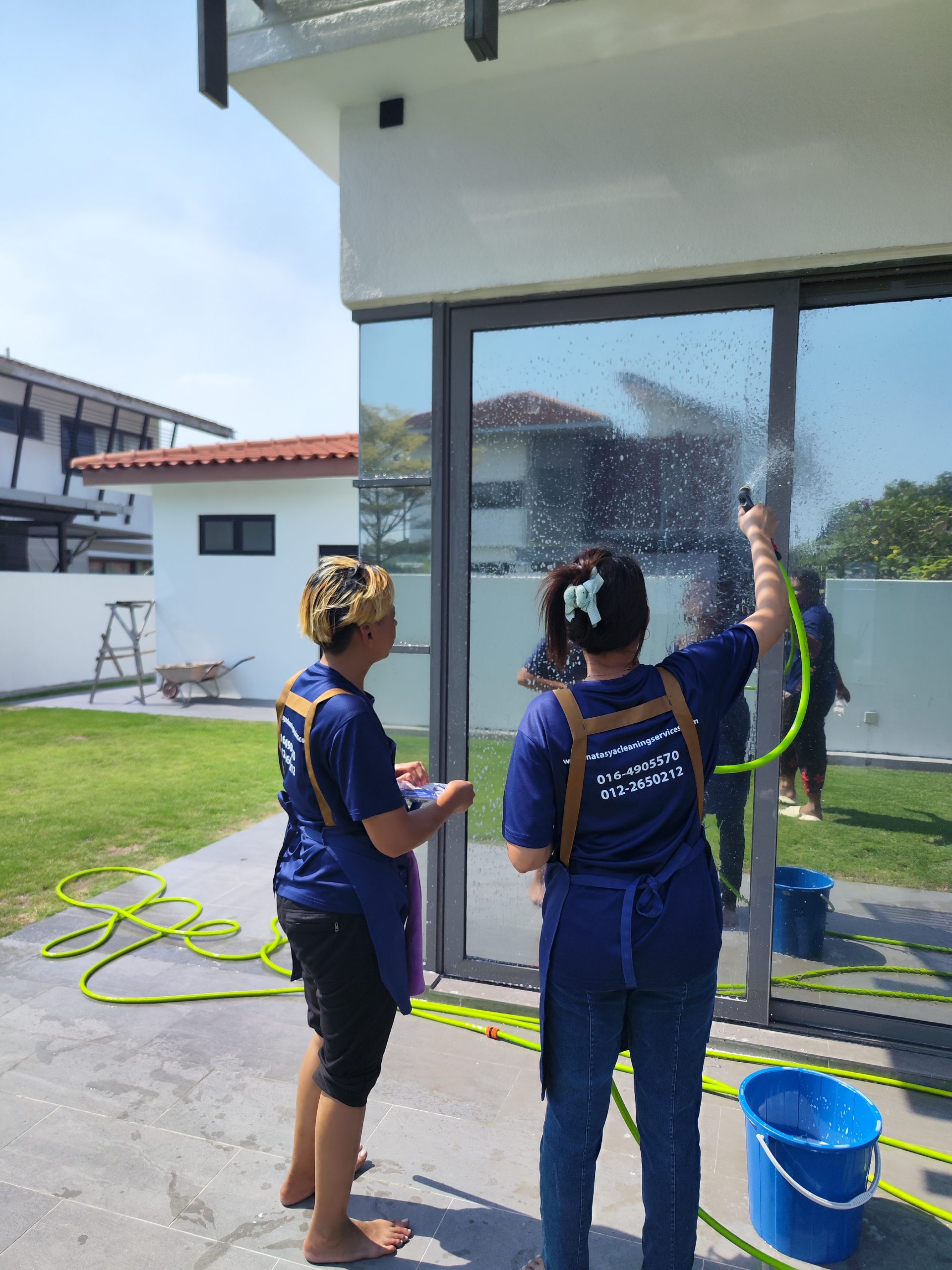 Natasya cleaning team washing exterior glass panels at a residential property
